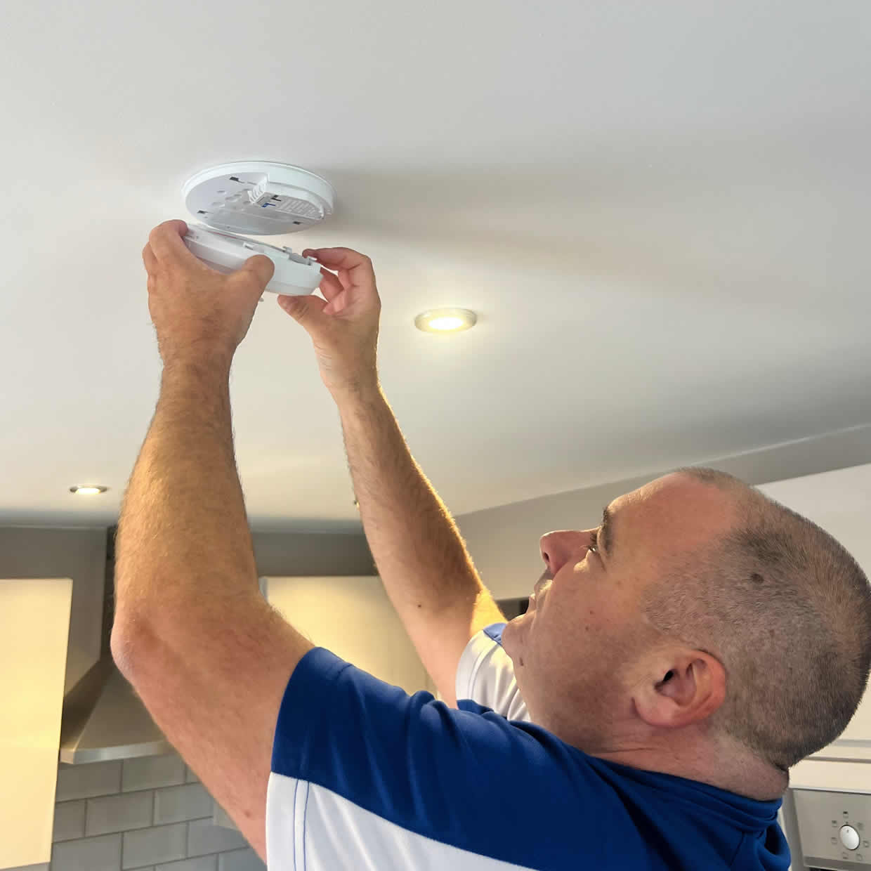 Smoke alarm installer fitting an alarm in a Ruislip property